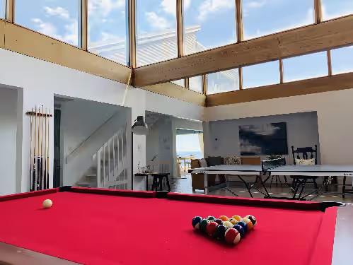 Enjoy the natural lighting of the game room with scenic ocean views at Unobstructed Direct Oceanfront in Seaside