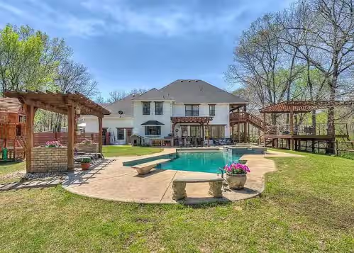 Enjoy this backyard oasis. A pool with a diving board, and deck with creek views at Winter discounts! Enjoy the hot tub,